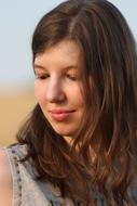 Portrait of the girl in sunlight, at blurred background