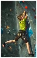 Woman, climbing on the colorful wall, in light