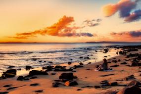 girl among the stones on the beach at dusk