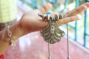 old jewelry in hand on blurred background