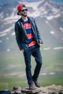 trendy stylish guy posing in the mountains