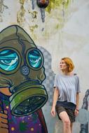 woman posing near funny graffiti