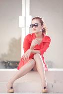 Young elegant Woman sits on step in front of door