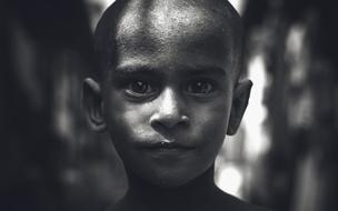 Black and white photo of the portrait of the boy kid in light and shadows