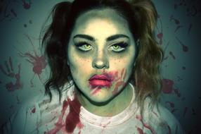 Woman in zombie make-up and bloody hand prints