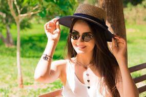 young woman in hat on bench on blurred background