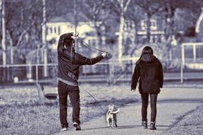 man and a woman with a dog for a walk