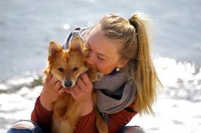 young Woman kissing red Dog