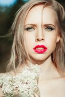 portrait of a blonde with bright red lips on a blurred background