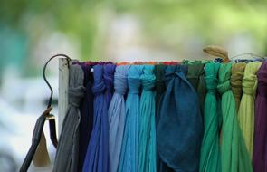 Close-up of the colorful scarves, on the stand, at blurred background