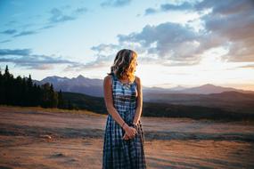 blonde woman stands at scenic Mountain landscape