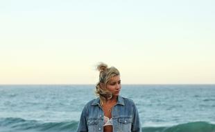 blonde in a denim jacket on the background of the sea