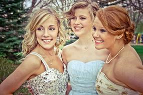 three smiling girlfriends in the park