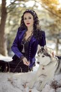 beautiful woman posing with dog in nature in winter