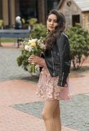 beautiful girl posing with a bouquet on the street