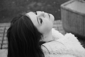 Black and white photo with the portrait of the young woman with closed eyes