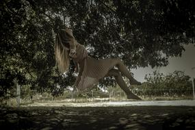 Woman in dress, levitating among the plants, outdoors