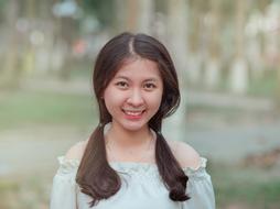 smiling pretty asian girl outdoor at blur background