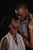 Smiling, African couple together, in light, at black background