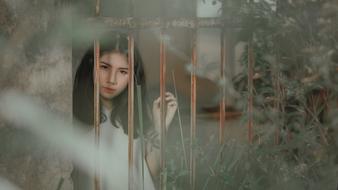 brooding brunette behind the fence