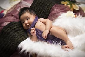 little girl on white fluffy blanket