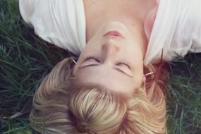 beautiful young woman lays on Green Grass