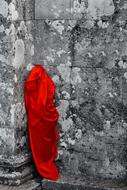 person covered with Red Fabric at grey wall