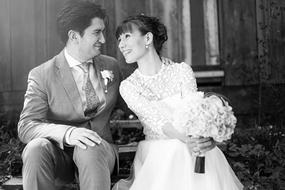 Black and white photo of the bride and groom on the wedding, with flowers, in light