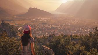 Back view with the girl looking on the beautiful and colorful landscape with plants and buildings, among the mountains