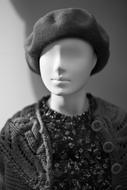 black and white photo of a mannequin in a jacket and a hat