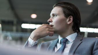 Profile portrait of the man, in suit with the tie, in the building with light