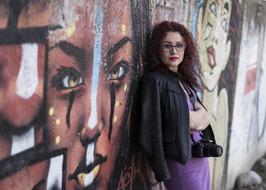 fashionable woman in glasses on a wall background with graffiti