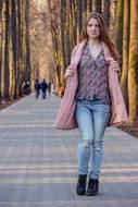 a girl in a pink jacket walks down the alley