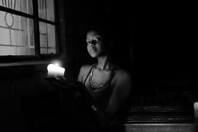 portrait of Adult Woman with candle in dark room