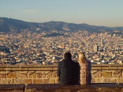 People looking on the colorful landscape of Barcelona, Spain, with mountains, while sitting