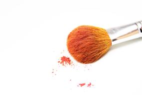 Close-up of the colorful brush with cosmetics, on the white surface