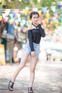 Smiling girl, posing outdoors, near the colorful hanging flags