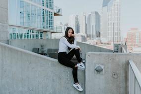 girl sitting on a concrete slab near the building