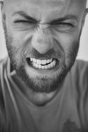 Black and white portrait of the bearded man, showing teeth