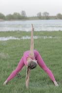 girl doing yoga in a pink suit on the street