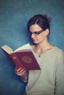 serious Girl Reading thick book at wall