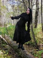 Woman in black clothing, among the beautiful and colorful plants of the forest