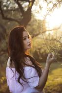 beautiful young brunette posing in nature in blurred background