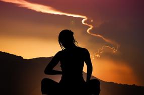 sky woman meditate at sunset