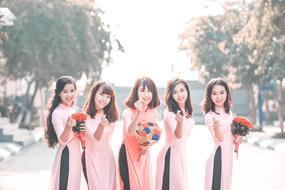 Smiling girls, with the beautiful and colorful flowers, outdoors