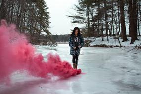 woman in winter posing in pink smoke