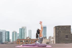 girl doing exercises on the roof of the building