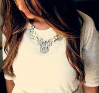 girl in a white blouse with a glamorous decoration on her neck