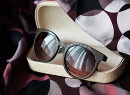 Close-up of the shiny glasses in the wooden case, in light