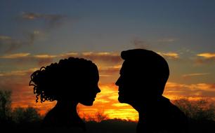 black silhouettes of lovers at sunset in dark twilight